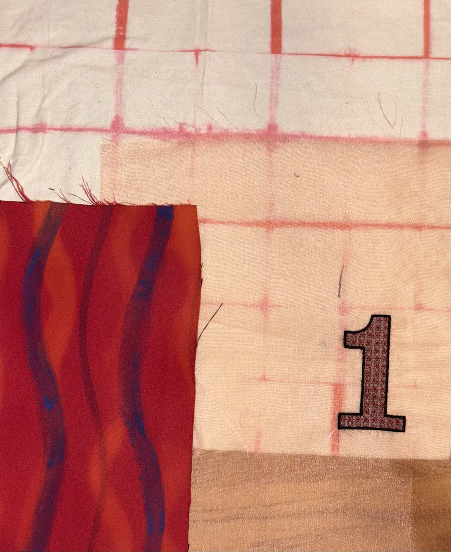 Number 1 appliqué on pink-dyed grid fabric, with a red and blue wave print.