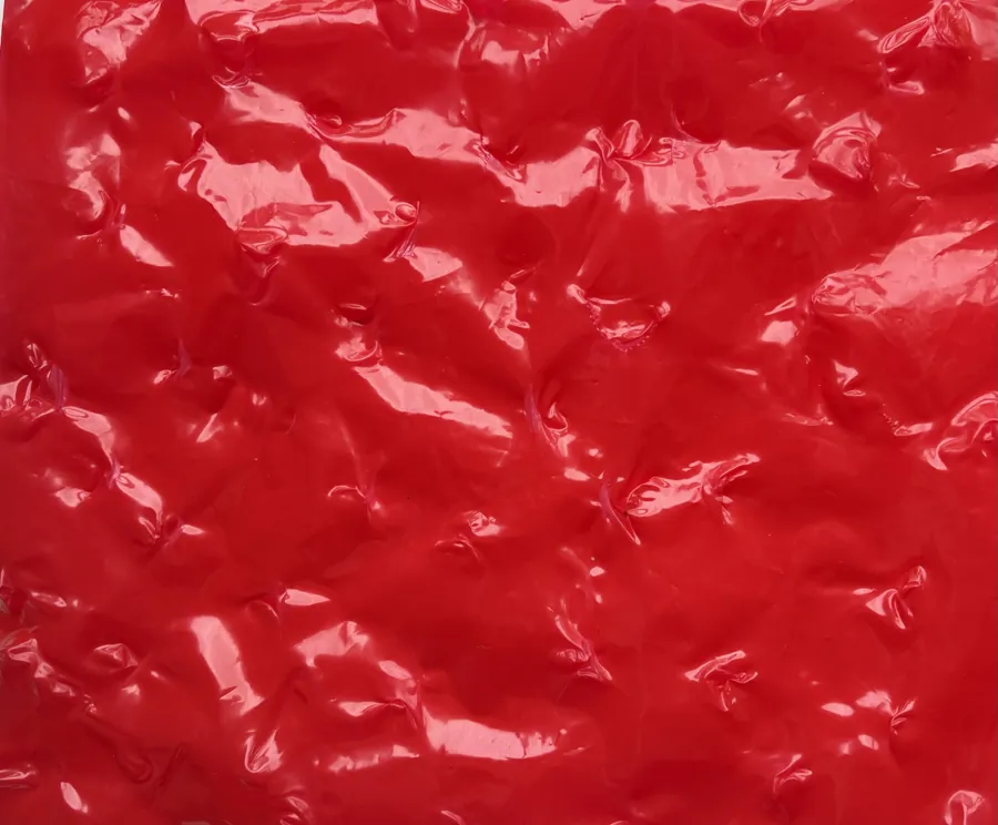 Close-up of glossy, wrinkled red plastic.